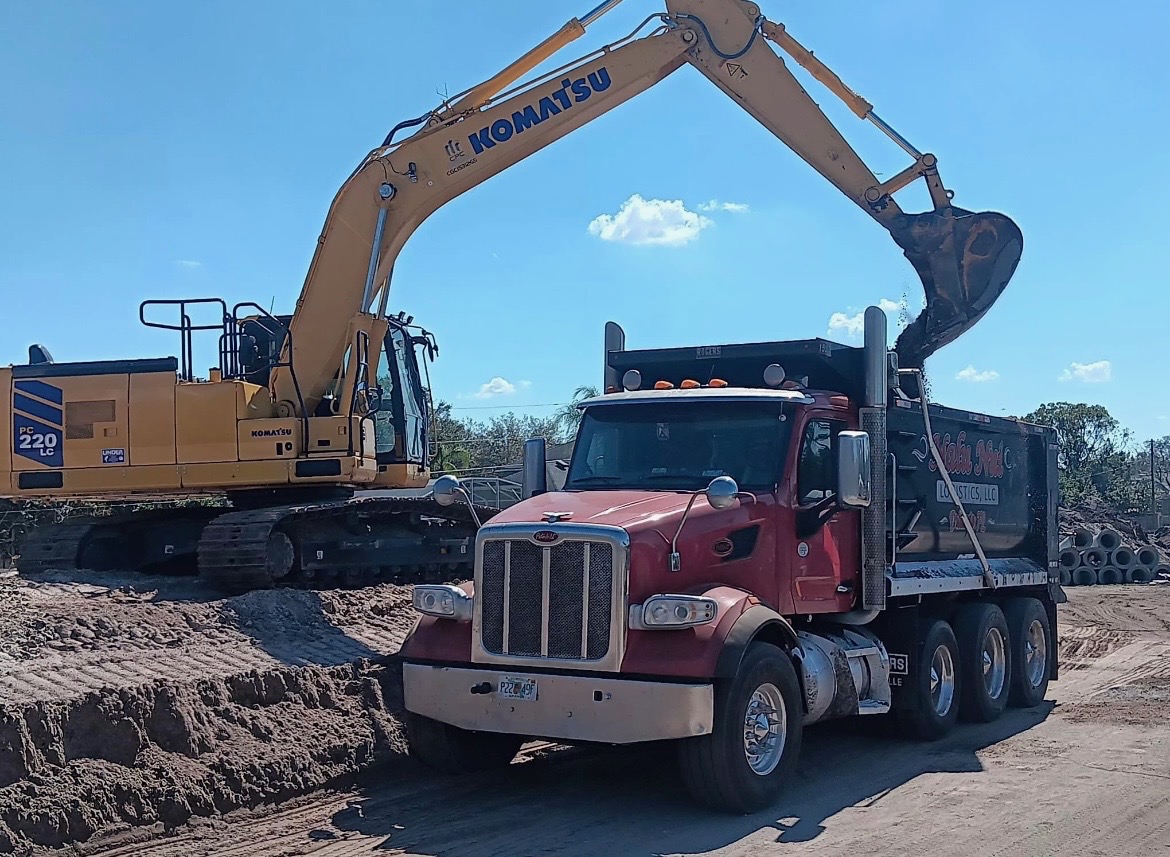 Nalu's Freight Solutions dump truck being loaded by excavator on active job site